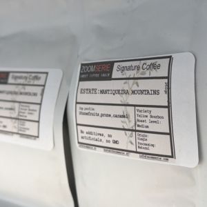 Close-up of a coffee bag label that says “Signature Coffee, Estate Mantiqueira Mountains,” with flavor notes like stone fruits, prune, caramel and roast level listed as Medium.
